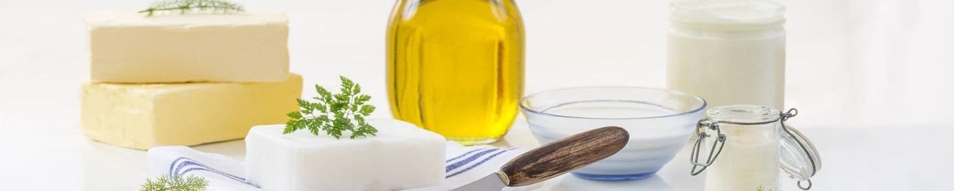 Ingredientes para la valoración de peróxido: mantequilla, aceite, crema y hierbas sobre una superficie blanca